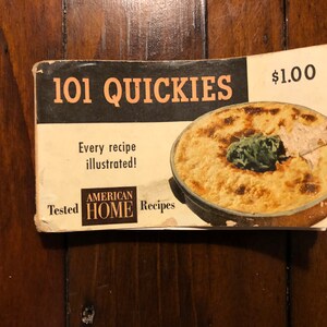 K&ouml;nnte beinhalten: Ein Vintage-Kochbuch mit dem Titel "101 Quickies" mit einem Foto einer Auflaufform auf dem Cover. Das Kochbuch kostet 1,00 $ und enth&auml;lt den Text "Jedes Rezept illustriert!" und "Getestete amerikanische Hausrezepte".