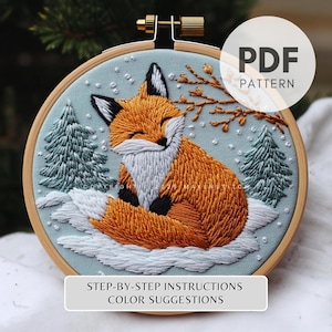 May include: Embroidered fox in a winter scene. The design features a smiling fox with orange fur, black accents, and white fur. Two green pine trees, a branch, and the text "PDF PATTERN" are included. The text "STEP-BY-STEP INSTRUCTIONS COLOR SUGGESTIONS" is also included.