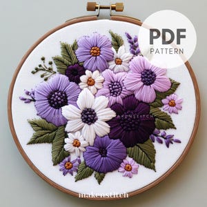 Könnte beinhalten: Ein PDF-Muster zum Sticken mit einem Strauß aus lila, weißen und grünen Blumen in einem Reifen. Das Muster trägt den Titel "PDF PATTERN".