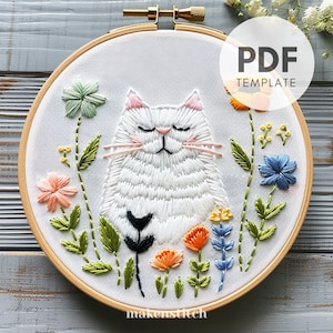 以下が含まれることがあります： 閉じた目をした白い猫がカラフルな花に囲まれている刺繍パターンのPDFテンプレート。初心者向けの刺繍プロジェクトに最適なデザインです。