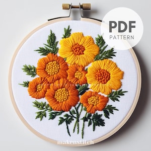 May include: Embroidered hoop art featuring a bouquet of orange and yellow flowers with green leaves. The hoop is made of wood and has a white background. The text "PDF PATTERN" is printed in black on a white background.