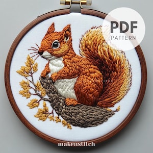Puede incluir: Patrón bordado de una ardilla roja sentada en una rama con hojas de otoño. El patrón está en un aro y está etiquetado como "PDF PATTERN".