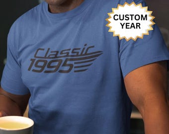 May include: A blue t-shirt with the text "Classic 1995" in black. The text is stylized with a wing design. A yellow starburst sticker with the text "Custom Year" is on the shirt.