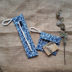 May include: Two blue and white patterned fabric pouches with drawstring closures. One pouch contains a wooden toothbrush and the other contains a bar of soap.