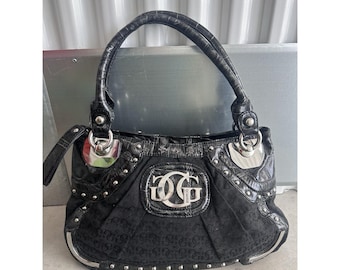 May include: Black handbag with a textured handle and silver-tone hardware. The bag features a repeating pattern and a large silver "GG" logo on the front. The bag has a structured shape and a glossy finish.