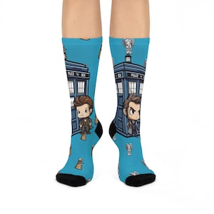 May include: A pair of blue socks with a Doctor Who theme. The socks feature a blue police box, Daleks, and the Doctor. The text "Police Box" is printed on the police box.