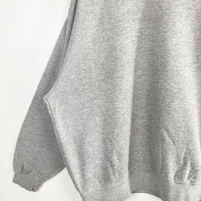 May include: A heather gray sweatshirt with a crew neck and long sleeves. The sweatshirt is made of a soft, comfortable material. The cuffs and hem are ribbed.