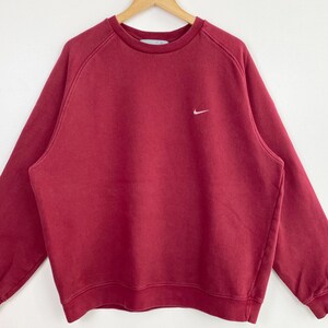May include: A red crew neck sweatshirt with a white Nike swoosh logo on the left chest.