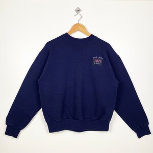 May include: A navy blue sweatshirt with a white embroidered logo that says "Golf Jersey Dad Academy".