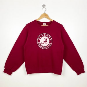 May include: Crimson red sweatshirt with a white Alabama Crimson Tide logo featuring a large "A" in a circle.