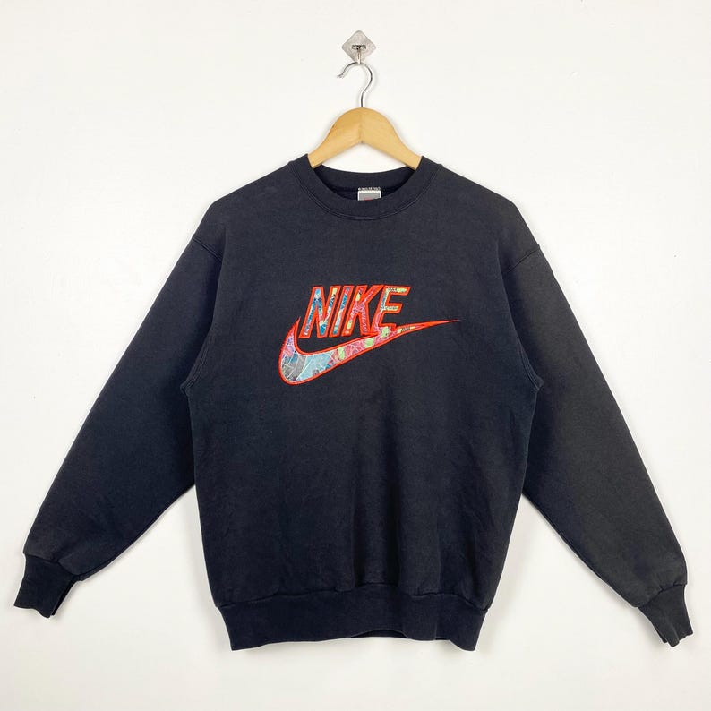 May include: Black Nike sweatshirt with a large, colorful, embroidered logo that says "NIKE" on the front.