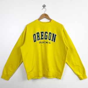 May include: Yellow sweatshirt with the text "OREGON DUCKS" in green and black lettering.