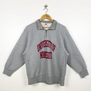 May include: Gray sweatshirt with a quarter zip closure and the text "University of Minnesota" in maroon.