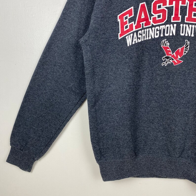 May include: A dark grey sweatshirt with the text "Eastern Washington University" and a red and white eagle logo.