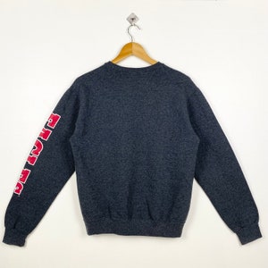 May include: A dark grey sweatshirt with red lettering on the left sleeve that reads "Fight The"