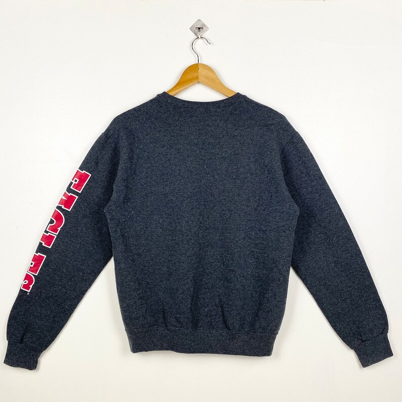 May include: A dark grey sweatshirt with red lettering on the left sleeve that reads "Fight The"