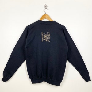 May include: Black long-sleeve sweatshirt with a gold graphic of a sun, mountains, and the word "TENNESSEE" on the back.