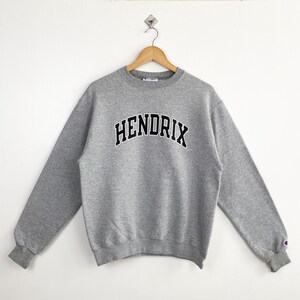 May include: A gray sweatshirt with the word "HENDRIX" printed in black on the front.