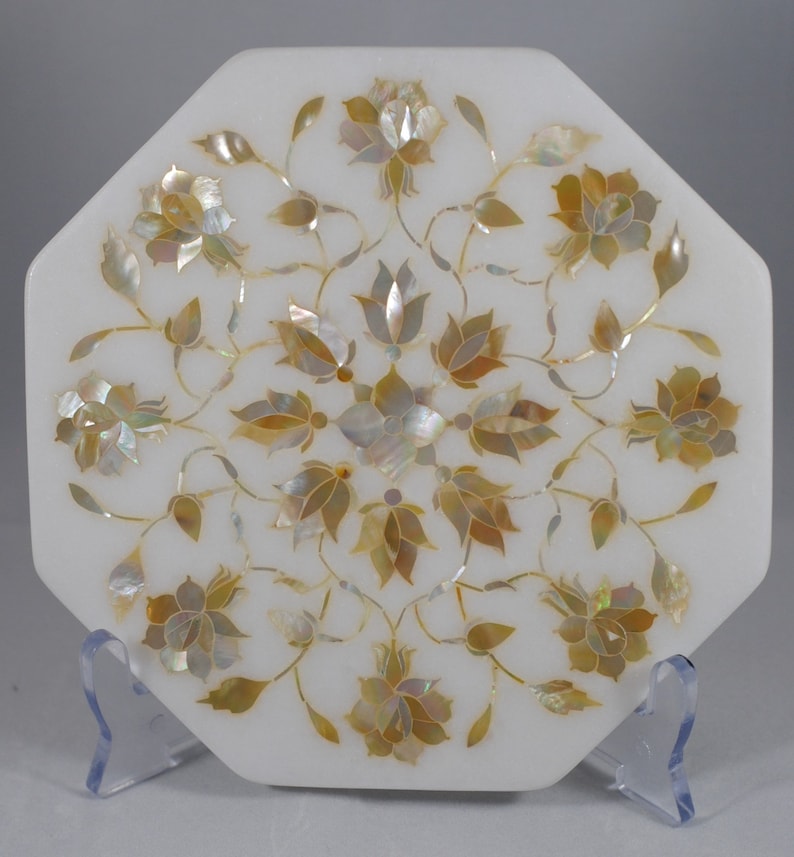 May include: White marble octagonal tray with a floral design inlaid with mother of pearl. The design features a central motif of a flower with eight petals surrounded by smaller flowers and leaves.
