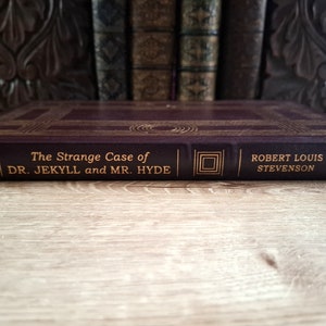 Pu&ograve; includere: Un libro rilegato in pelle bordeaux con lettere dorate sul dorso. Il titolo &egrave; "The Strange Case of DR. JEKYLL and MR. HYDE" di ROBERT LOUIS STEVENSON.
