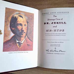 Pu&ograve; includere: Un libro vintage rilegato in pelle intitolato "Lo strano caso del dottor Jekyll e Mr. Hyde" di Robert Louis Stevenson. Il libro fa parte di una serie di edizioni da collezione, "I 100 migliori libri mai scritti", e presenta un'illustrazione dell'autore sulla copertina.