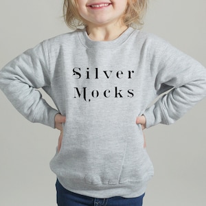 Puede incluir: Una sudadera gris con el texto "Silver Mocks" impreso en la parte delantera.