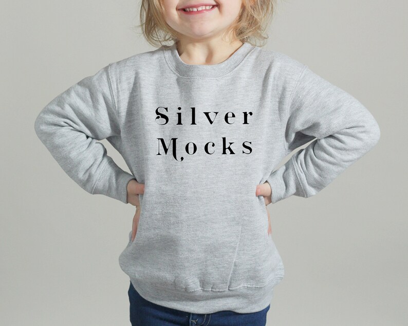 Puede incluir: Una sudadera gris con el texto "Silver Mocks" impreso en la parte delantera.