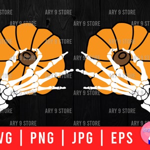 May include: Two orange pumpkins with a skeleton hand holding each one. The pumpkins are on a black wooden background.