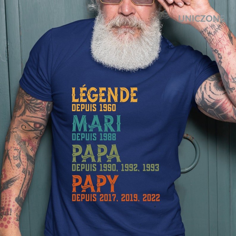 K&ouml;nnte beinhalten: Ein marineblaues T-Shirt mit einer Grafik im Vintage-Stil, auf dem "L&Eacute;GENDE DEPUIS 1960", "MARI DEPUIS 1988", "PAPA DEPUIS 1990, 1992, 1993" und "PAPY DEPUIS 2017, 2019, 2022" steht.