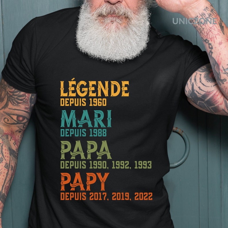 K&ouml;nnte beinhalten: Schwarzes T-Shirt mit einer Grafik im Vintage-Stil, die "L&Eacute;GENDE DEPUIS 1960 MARI DEPUIS 1988 PAPA DEPUIS 1990, 1992, 1993 PAPY DEPUIS 2017, 2019, 2022" lautet.