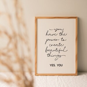 May include: A framed print with a white background and black text that reads "you have the power to create beautiful things. YES, YOU". The frame is made of light wood.