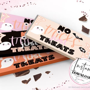Op de afbeelding: Drie Halloween-chocoladereepverpakkingen in roze, zwart en oranje. Elke verpakking heeft een spook, een spinnenweb en de tekst "No Tricks Just Treats". De verpakkingen zijn versierd met een vleermuis en een uil.