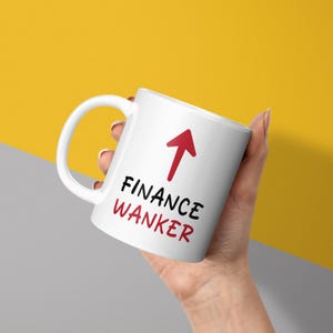 May include: White ceramic mug with a red arrow pointing upwards and the text "FINANCE WANKER" in black.