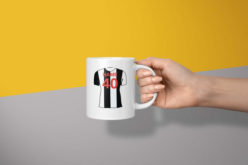 May include: White ceramic mug with a black and white football jersey design. The jersey has the word "NAME" and the number "40" printed on it.