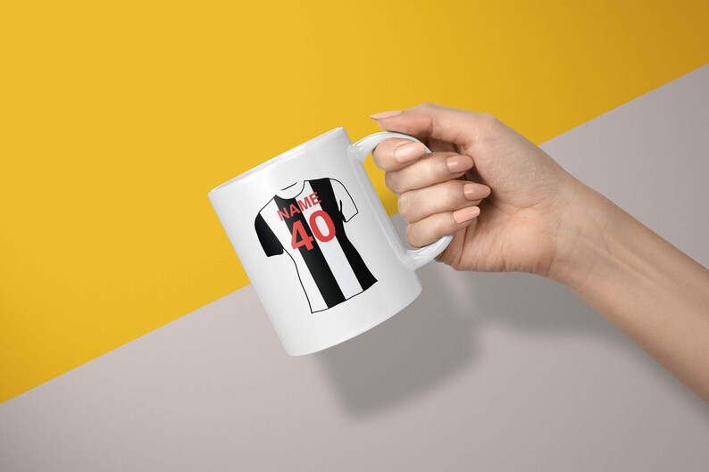 May include: White ceramic mug with a black and white football jersey design. The jersey has the word "NAME" and the number "40" printed on it.