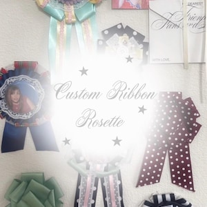 Puede incluir: Una colección de rosetas de cinta personalizadas en varios colores y diseños. Las rosetas presentan cintas en azul, verde y burdeos con lunares blancos. Algunas rosetas incluyen fotos y elementos decorativos.