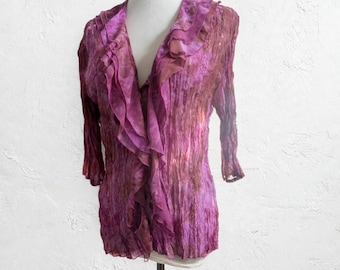 May include: A long-sleeved blouse in a vibrant magenta and deep purple tie-dye pattern. The garment features a V-neckline adorned with cascading ruffles along the front opening and a textured, crinkled fabric finish throughout the piece.