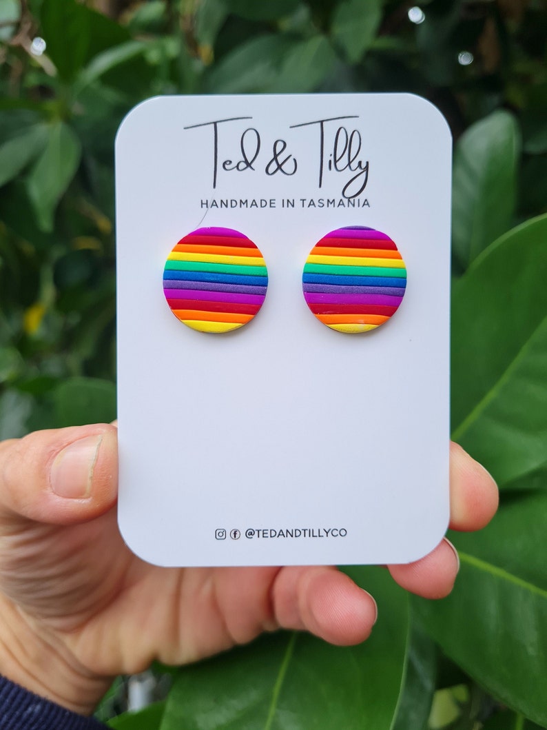 Op de afbeelding: Regenboogkleurige oorbel studs gemaakt van polymer clay. De oorbellen zijn handgemaakt in Tasmani&euml;, Australi&euml;. De oorbellen worden getoond op een witte kaart met de tekst "Ted & Tilly Handmade in Tasmania" en de social media handle "@tedandtillyco".