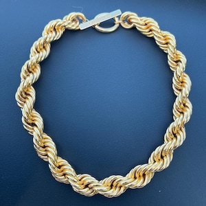 May include: A gold-toned rope chain necklace with a clasp.