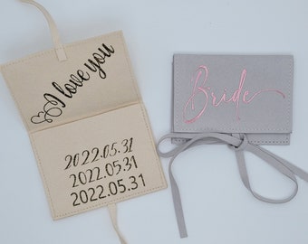 May include: Two small fabric pouches with a ribbon tie. One pouch is beige and says "I love you" and "2022.05.31" on the inside. The other pouch is gray and says "Bride" in pink lettering.