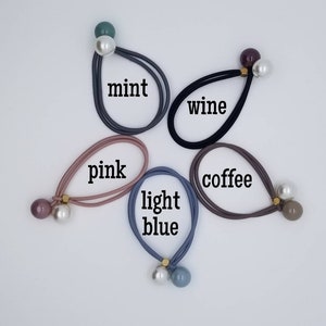 May include: Five hair ties with pearl and colored beads. The colors are mint, wine, pink, light blue, and coffee.