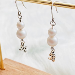 Pendientes colgantes personalizados de perlas dobles brillantes. Dijes con letras cursivas. Elegante tono plateado minimalista. Joya para damas de honor.