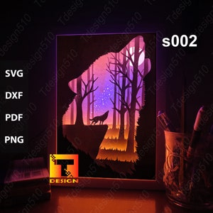 May include: A white frame with a wolf howling at the moon in a forest scene. The wolf is silhouetted against a purple sky with stars. The scene is illuminated from behind, creating a glowing effect.