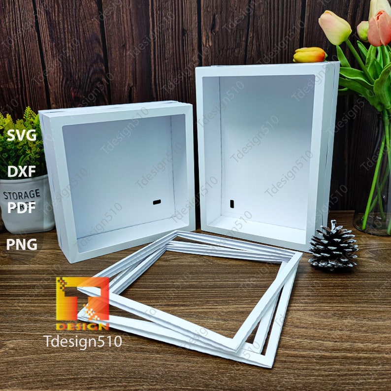 May include: White, square shadow box frames and a set of matching frames are displayed. The shadow boxes have a recessed interior and a small hole. The frames are stacked. The image also includes the text "SVG, DXF, STORAGE, PDF, PNG" and the logo "Tdesign510".