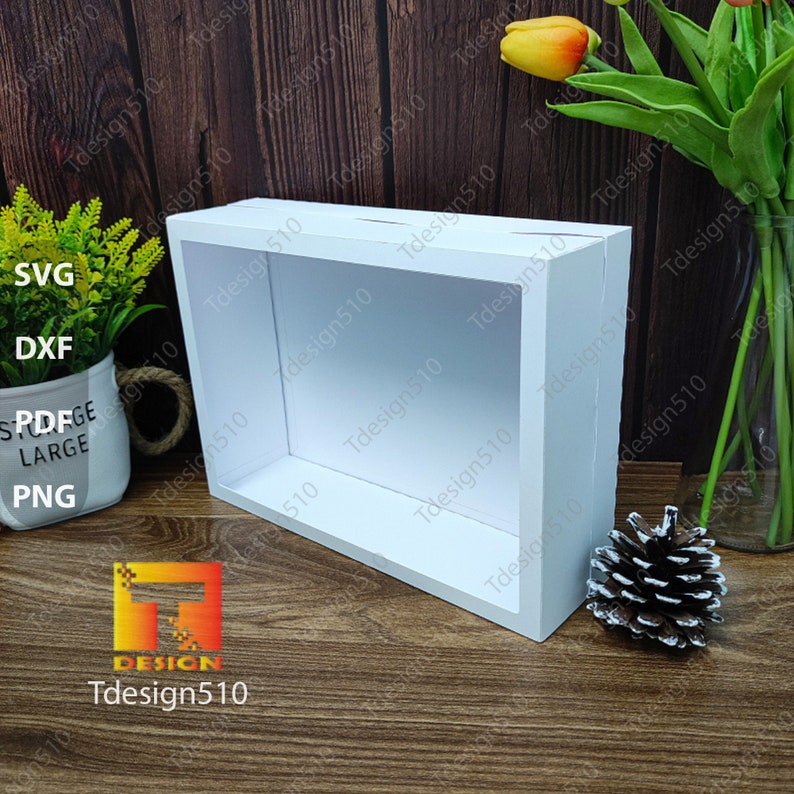 May include: A white rectangular shadow box with a hollow interior, perfect for displaying items. The box is made of a smooth, solid material. The image also includes the text "SVG, DXF, PDFGE, LARGE, PNG" and the logo "Tdesign510".