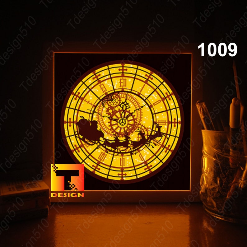 May include: A square, illuminated wall art piece featuring a clock design with a Santa Claus sleigh silhouette. The clock face is yellow with a brown sleigh and reindeer. The text "1009" is in the upper right corner. The "T DESIGN" logo is in the lower left corner.