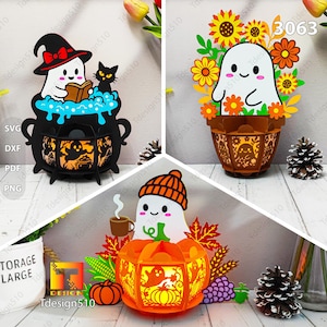 May include: A collage of three Halloween-themed paper cutouts. One features a ghost in a witch hat reading a book, another a ghost in a flower basket, and the last a ghost in a pumpkin with a coffee cup. The designs are intricate and colorful.