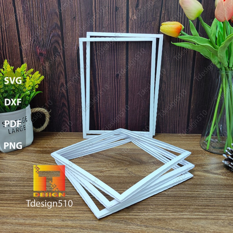 May include: Several white picture frames are stacked and arranged on a wooden surface. The frames are square with a textured, raised border. The image also includes a small plant, a vase of flowers, and the text "Tdesign510".