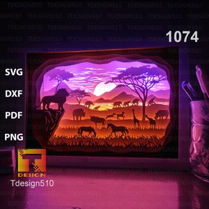 May include: A digital file for a 3D papercraft model of a sunset scene in the African savanna. The scene includes a lion, giraffes, zebras, elephants, and a rhino. The file is available in SVG, DXF, PDF, and PNG formats. The file number is 1074.