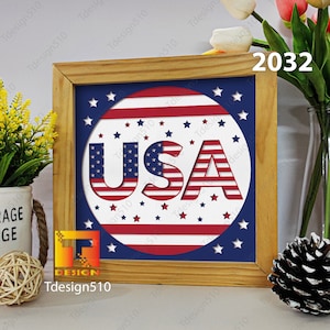 May include: A wooden framed picture with a red, white, and blue circle design. The circle has the word "USA" in the center with stars surrounding it. The number "2032" is written in the top right corner of the image.